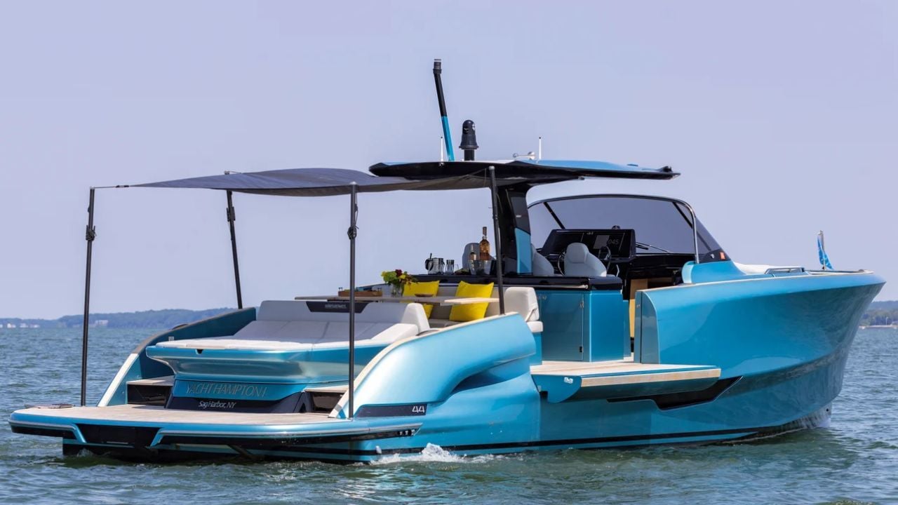 Luxury motor yacht cruising in South Florida with shaded deck and vibrant blue hull.