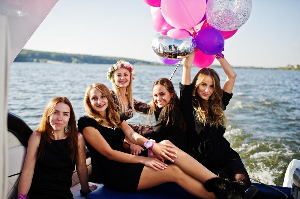 Birthday celebration with balloons on yacht under clear skies.