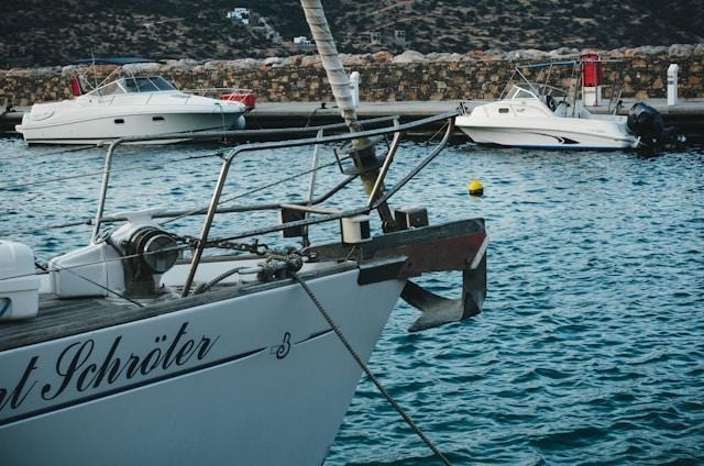 Sailboat bow at marina with docked boats
