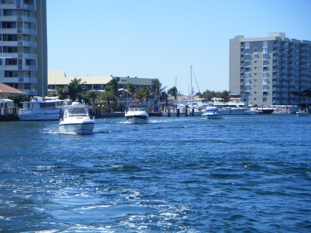 Motorboats cruising near waterfront towers at Lake Boca Sandbar.